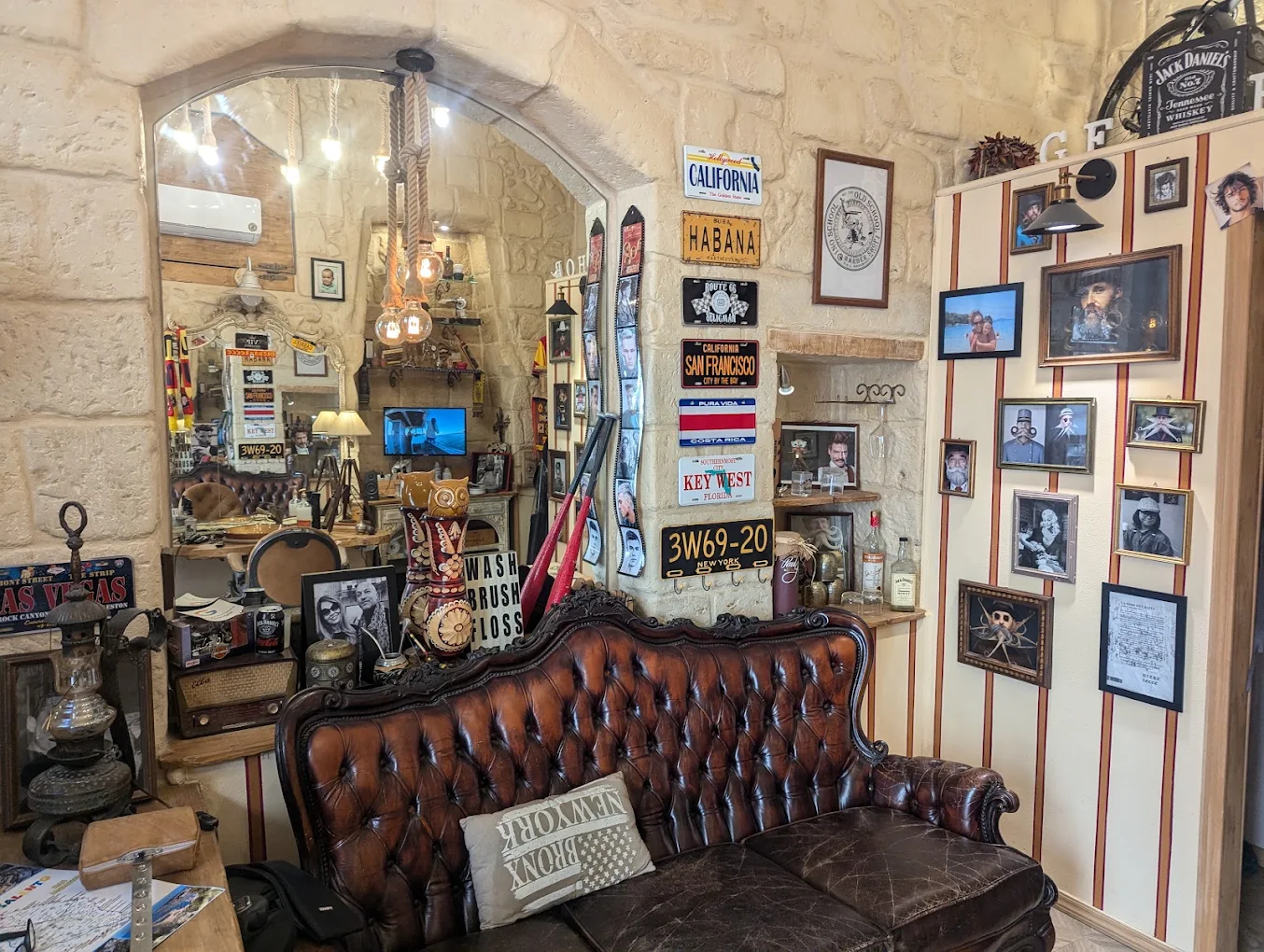 La sala d'attesa del Barbershop GF: divano chesterfield in cuoio sotto la volta in pietra leccese