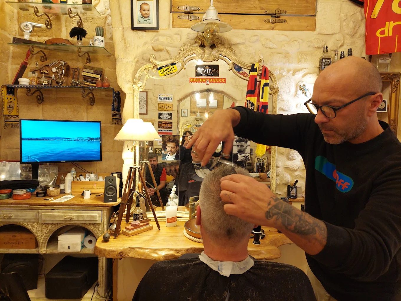 Il barbiere al lavoro sulla poltrona del Barbershop GF